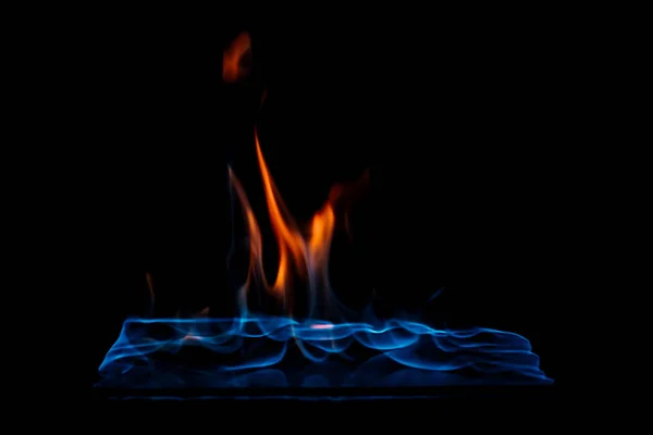 Close up view of burning orange and blue flame on black background — Stock Photo