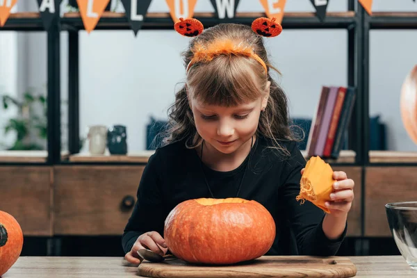 Portrait of adorable child at tabletop with pumpkin for halloween at home — Stock Photo