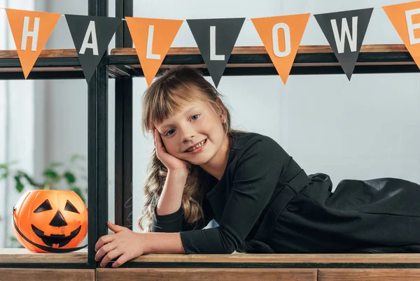 Portrait of smiling kid looking at camera in decorated room for halloween — Stock Photo