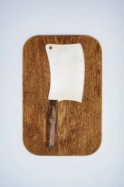 Вид сверху на мясной нож на деревянной доске, изолированный на сером — стоковое фото
