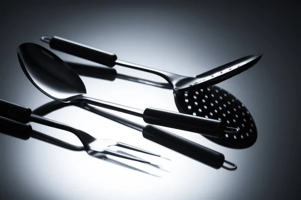 Close-up view of colander, fork with two tines and ladle on grey — Stock Photo