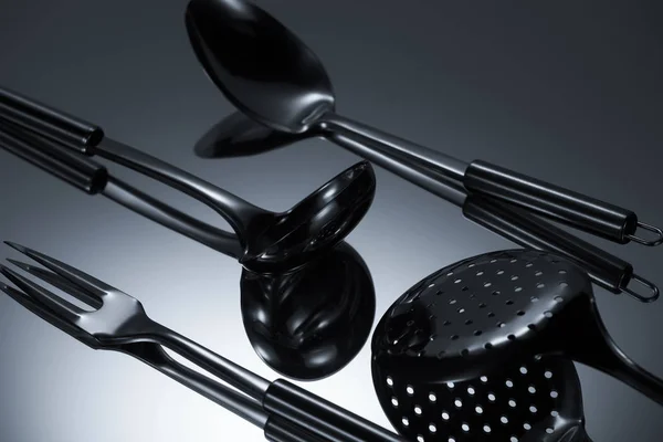 Close-up view of shiny stainless steel utensils reflected on grey — Stock Photo