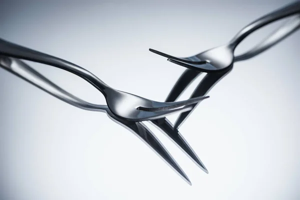Close-up view of shiny forks with two tines reflected on grey — Stock Photo