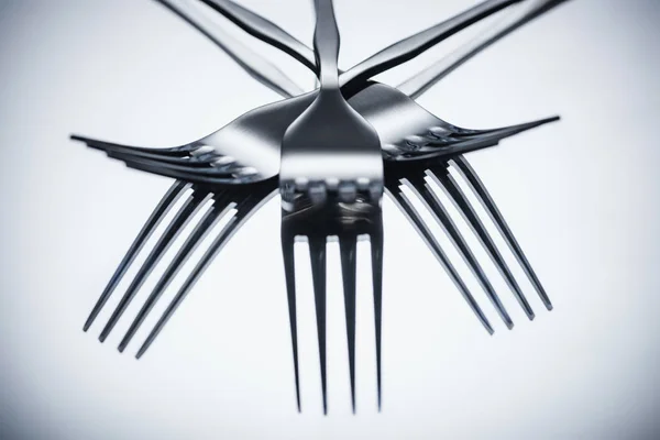 Close-up view of shiny stainless steel forks reflected on grey — Stock Photo