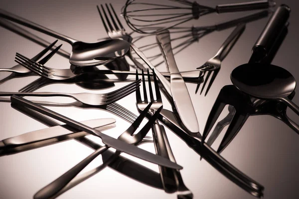 Vista ravvicinata di vari utensili in acciaio inox lucido su grigio — Foto stock