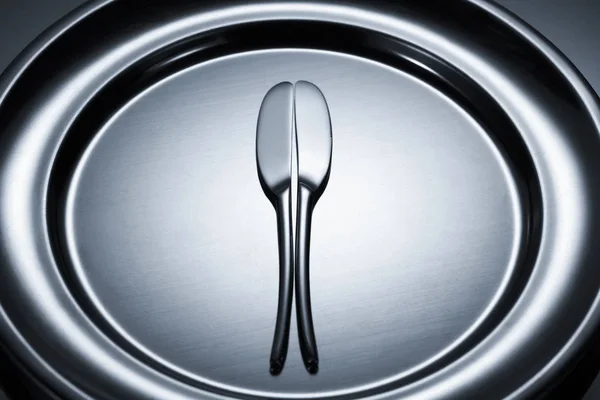 Close-up view of two knives on shiny metal tray on grey — Stock Photo