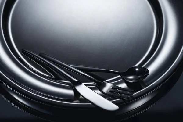 Close-up view of cutlery on shiny metal tray on grey — Stock Photo