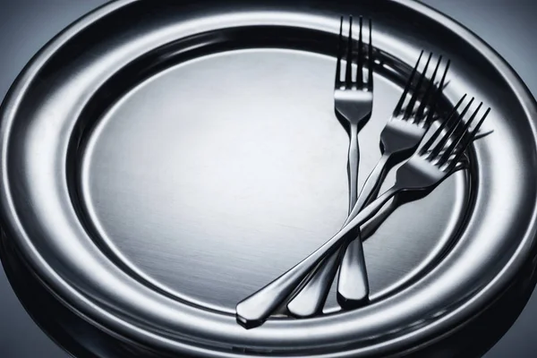 Close-up view of three shiny forks on metal tray on grey — Stock Photo