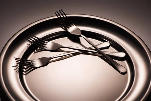 Close-up view of three forks on shiny metal tray on grey — Stock Photo
