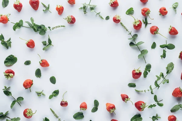 Top view of round frame made of ripe strawberries with mint leaves on white tabletop — Stock Photo