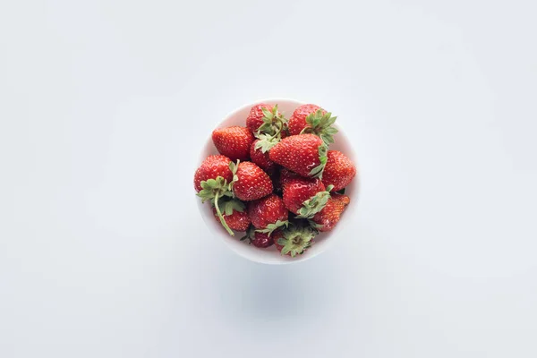 Draufsicht auf Schüssel mit reifen Erdbeeren auf weißer Tischplatte — Stockfoto