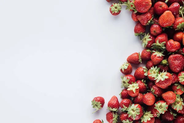 Top view of pile of strawberries on white surface with blank copy space — Stock Photo