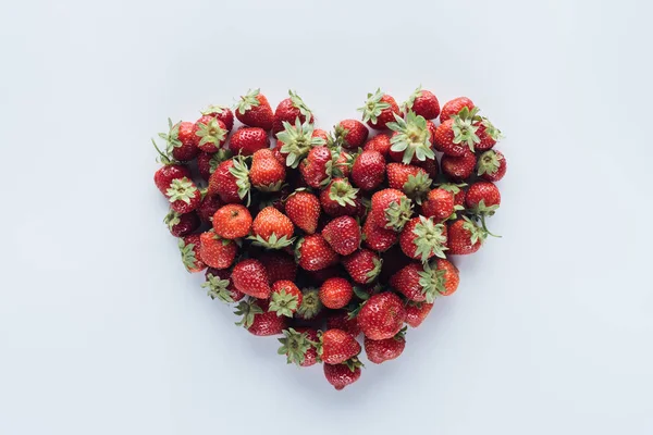 Vue du haut du panneau de forme de coeur en fraises mûres sur surface blanche — Photo de stock