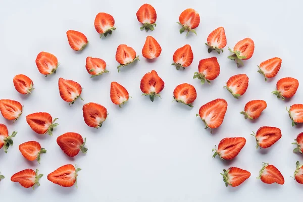 Draufsicht auf runde Zusammensetzung reifer halbierter Erdbeeren auf weißer Oberfläche — Stockfoto