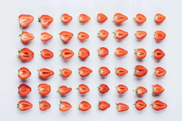 Vue de dessus de la composition des fraises mûres coupées en deux sur la surface blanche — Photo de stock