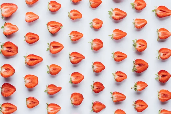 Zusammensetzung halbierter Erdbeeren auf weißer Oberfläche — Stockfoto