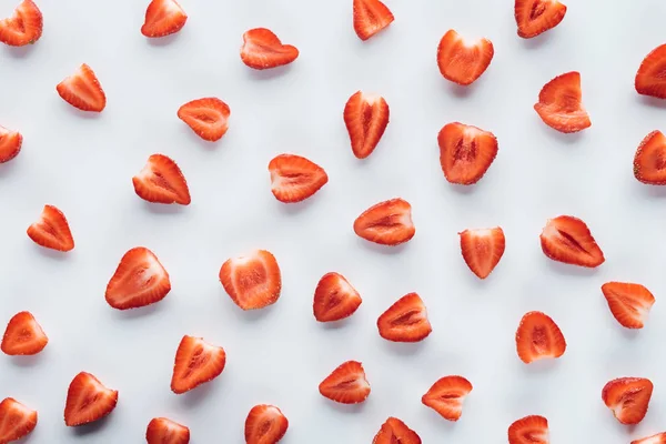 Draufsicht auf frische halbierte Erdbeeren auf weißer Oberfläche — Stockfoto