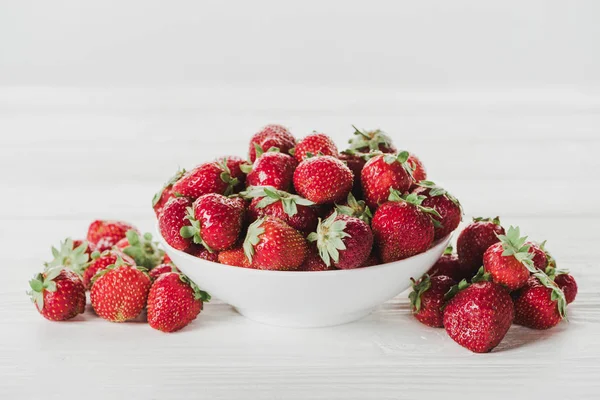 Gros plan du bol de fraises sur la surface blanche — Photo de stock