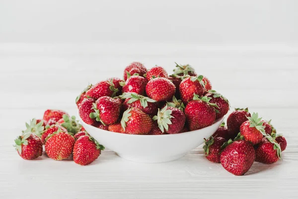 Close-up shot of bowl of strawberries on white surface — Stock Photo