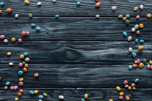 Vista elevada de coloridos caramelos deliciosos arreglados sobre fondo de madera - foto de stock