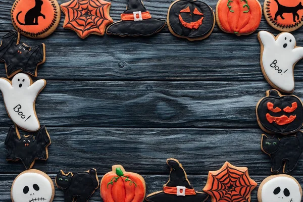 Rahmen aus gruseligen Halloween-Plätzchen auf schwarzem Holzhintergrund — Stockfoto