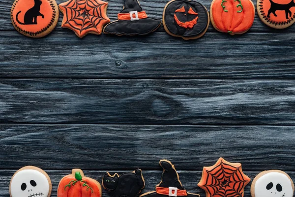 Vista dall'alto di biscotti fatti in casa di Halloween disposti disposti in file su sfondo di legno — Foto stock