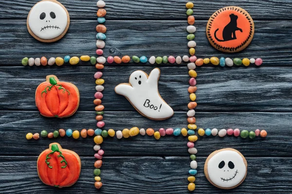 Top view of composition from colorful candies and spooky halloween cookies on wooden table — Stock Photo