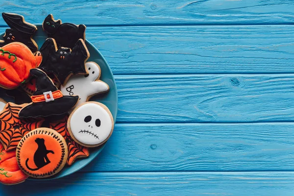 Top view of plate with delicious homemade halloween cookies on wooden background — Stock Photo