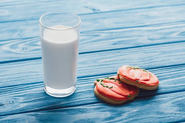 Close up view of homemade halloween cookies and glass of milk on wooden table — Stock Photo