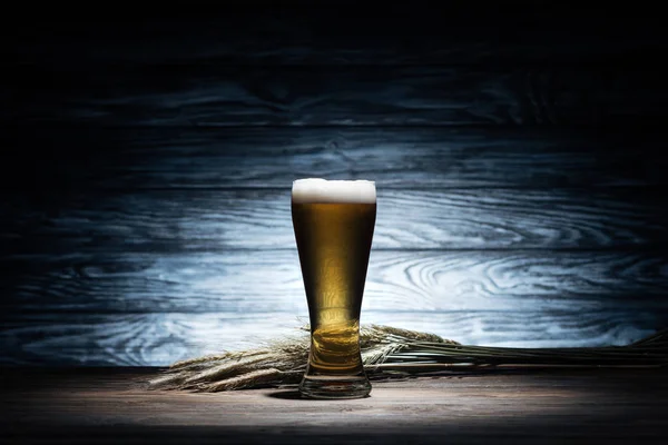 Verre de bière savoureuse et épillets de blé sur table en bois, concept oktoberfest — Photo de stock
