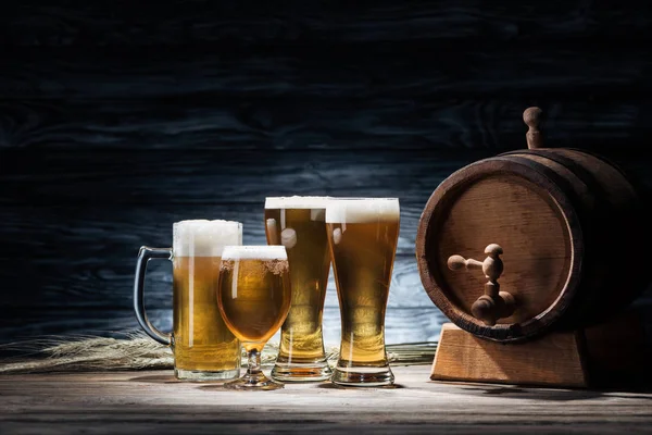 Verres de bière savoureuse, épillets de blé et tonneau de bière sur table en bois, concept oktoberfest — Photo de stock