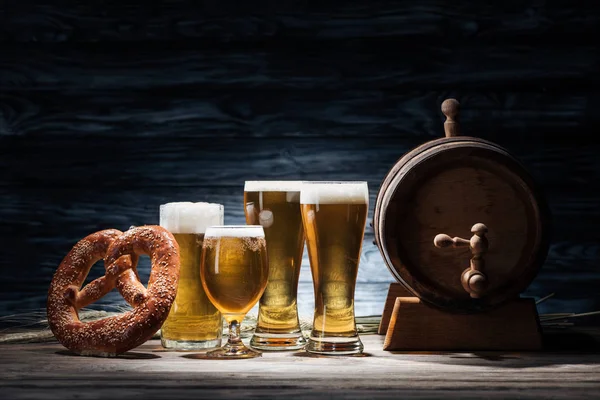 Cerveza en vasos, pretzel y barril de cerveza en mesa de madera, concepto oktoberfest - foto de stock