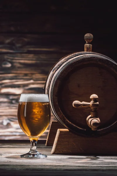 Склянка свіжого пива і пивного бареля на дерев'яному столі, концепція — стокове фото