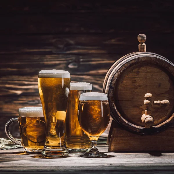 Fresh beer in glasses and beer barrel on wooden table, oktoberfest concept — Stock Photo