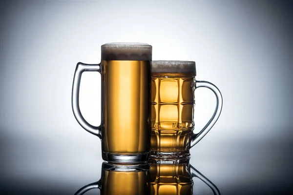 Beer in glasses on reflecting surface, oktoberfest concept — Stock Photo