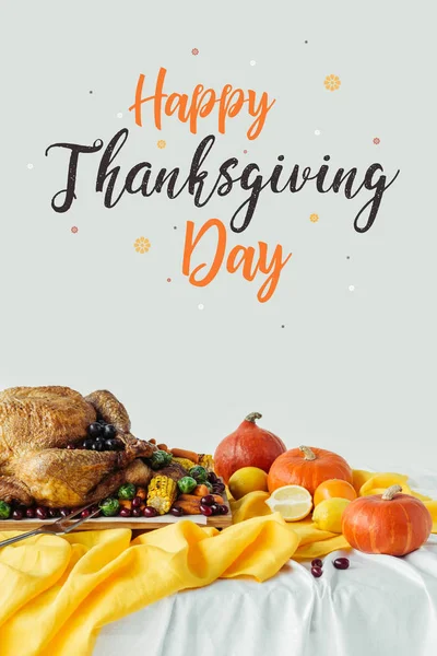 Nahaufnahme von gebratenem Truthahn, Kürbissen und Happy Thanksgiving Day Schriftzug auf grauem Hintergrund — Stockfoto