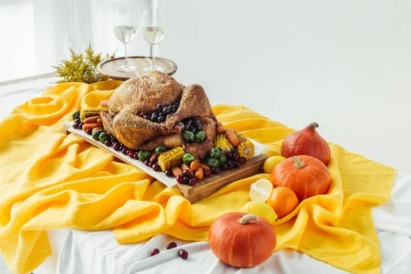 Close up view of festive thanksgiving dinner table set with glasses of wine, roasted turkey and vegetables on tabletop with tablecloth — Stock Photo