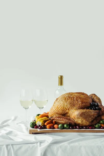 Vista de perto da mesa de jantar festiva de ação de graças com copos de vinho, peru assado e legumes na mesa com toalha de mesa branca — Fotografia de Stock