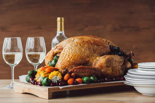 Close up view of traditional roasted turkey, vegetables and glasses of wine for thanksgiving dinner — Stock Photo