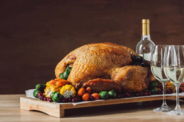 Close up view of traditional roasted turkey, vegetables and glasses of wine for thanksgiving dinner — Stock Photo