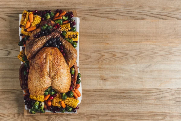 Draufsicht auf gebratenen Truthahn und Gemüse zum Erntedank traditionelles Abendessen auf hölzerner Tischplatte — Stockfoto