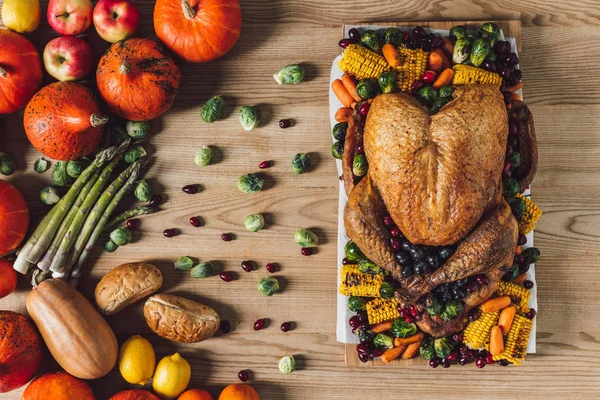 Draufsicht auf gebratenen Truthahn und Gemüse zum Erntedank traditionelles Abendessen auf hölzerner Tischplatte — Stockfoto