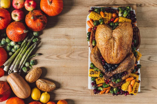 Draufsicht auf gebratenen Truthahn und Gemüse zum Erntedank traditionelles Abendessen auf hölzerner Tischplatte — Stockfoto