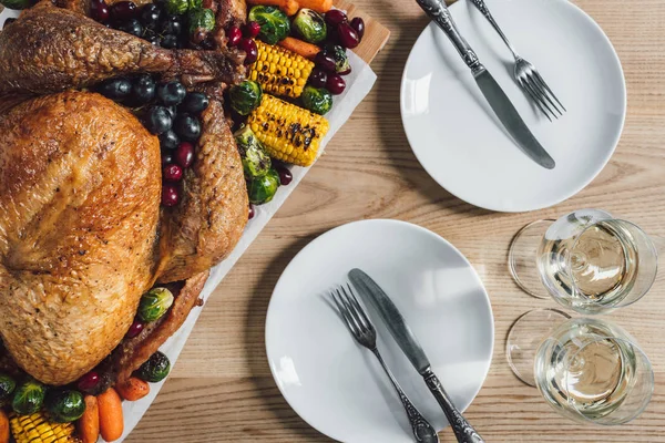 Flat lay with roasted turkey, vegetables and glasses of wine for thanksgiving holiday dinner on tabletop — Stock Photo