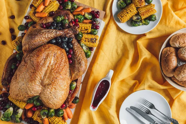 Acostado plano con pavo asado, verduras y salsa para la cena de Acción de Gracias en la mesa - foto de stock
