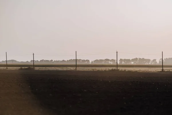 Scène rurale avec champ et tours électriques à la campagne — Photo de stock