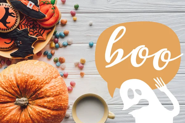 Vista sopraelevata di zucca, piatto con biscotti di Halloween, caramelle e tazza con latte su sfondo di legno con fantasma e segno 