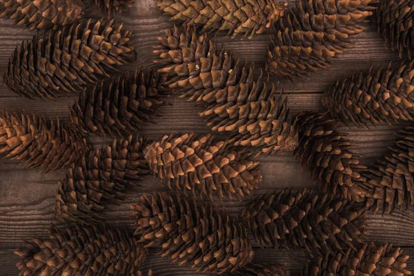 Top view of brown pine cones on wooden background — Stock Photo