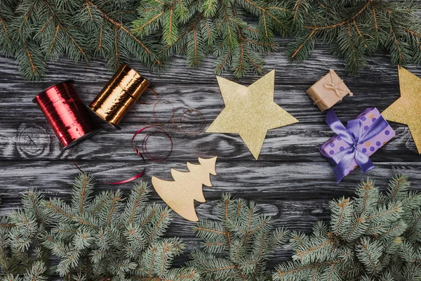 Vue de dessus de belles brindilles de sapin à feuilles persistantes et décorations de Noël sur fond en bois — Photo de stock