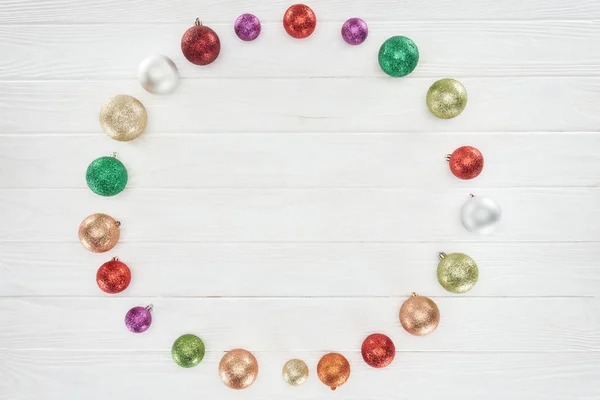 Top view of beautiful shiny colorful baubles on wooden surface, christmas background — Stock Photo